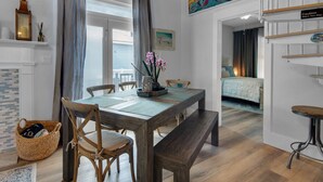 A cozy room with a wooden dining table, chairs, a bench, and a bed with a headboard. - Pool | Quiet Street | Steps to Beach | Chef's Kitchen | Large Yard (Destin)