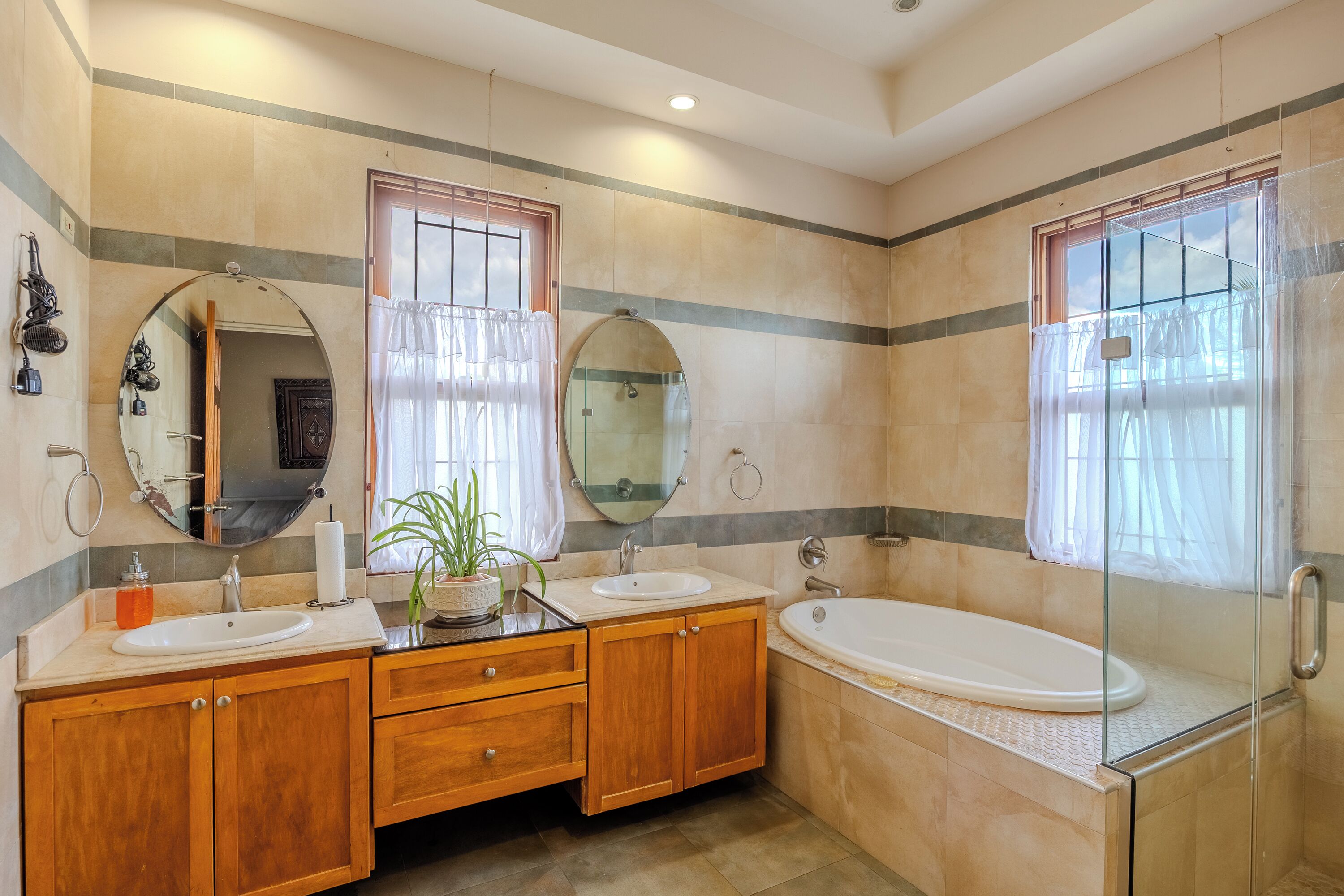 A bathroom with two sinks, a bathtub, a shower, and a large mirror.