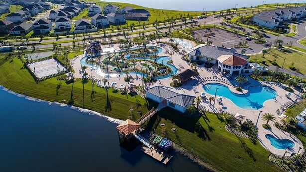 Een luchtendichtbeeld van een resort met meerdere zwembaden, een jachthaven en diverse gebouwen, waaronder een groot resortgebouw en verschillende kleinere huizen.