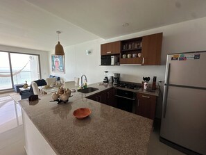 A modern kitchen with granite countertops, stainless steel appliances, and wooden cabinets.