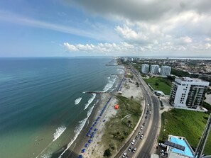 An aerial view of a coastal city with a beach, a road, and high-rise buildings. - Beachfront Apartment, Pool, Sauna, Jacuzzis, Gym. 5 Min Historical Center (Cartagena)