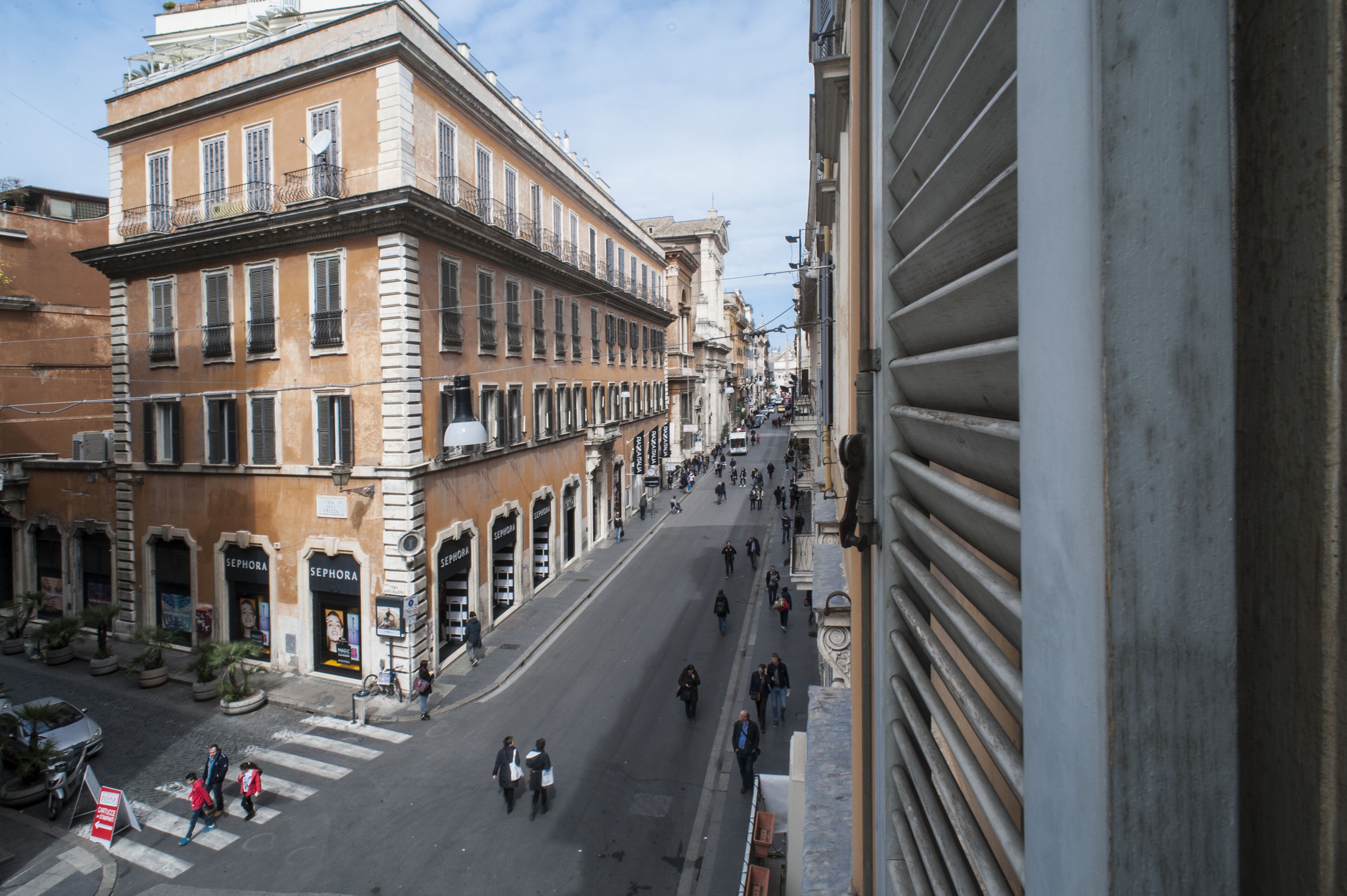 Une vue de rue avec un immeuble doté de fenêtres en arc de cercle et un magasin Sephora au rez-de-chaussée.