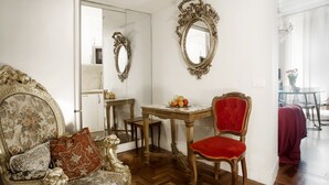 A room with ornate furniture, a mirror, and a table with fruit.