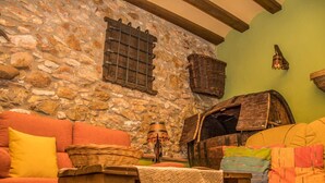 A cozy room with a stone wall, a wooden barrel, and a rustic wooden bench.