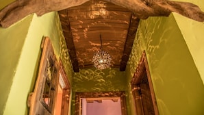 A hallway with a wooden ceiling and a hanging light fixture.