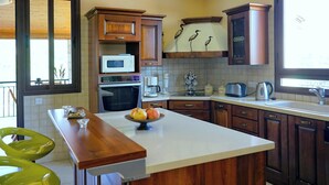 A kitchen with wooden cabinets, a microwave, a coffee maker, and a toaster. - Elite, Spectacular Villa Enormous HEATED Pool Gym Excellent Location - Sleeps 15 (Argaka)