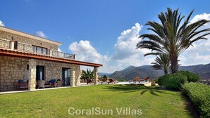 A villa with a stone facade, outdoor seating, and a view of mountains. - Elite, Spectacular Villa Enormous HEATED Pool Gym Excellent Location - Sleeps 15 (Argaka)