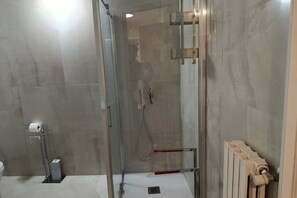 Kombination af bruser/badekar, hårtørrer, bidet, håndklæder