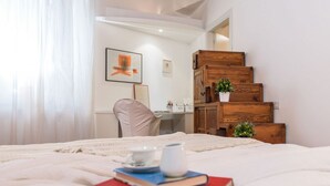 Une chambre à coucher avec un lit, un bureau, une chaise et un escalier.