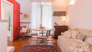 Un salon chaleureux comprenant un coin repas, un canapé, une table basse et une cheminée.