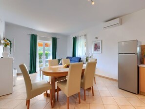 Enjoy meals in the dining area with a round table and four chairs, and relax on the sofa near large windows.