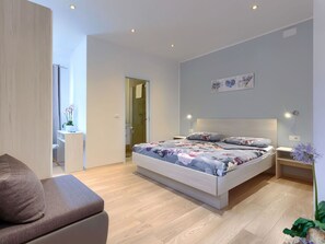 Relax in a serene bedroom with a large bed, bedside table, and modern amenities.
