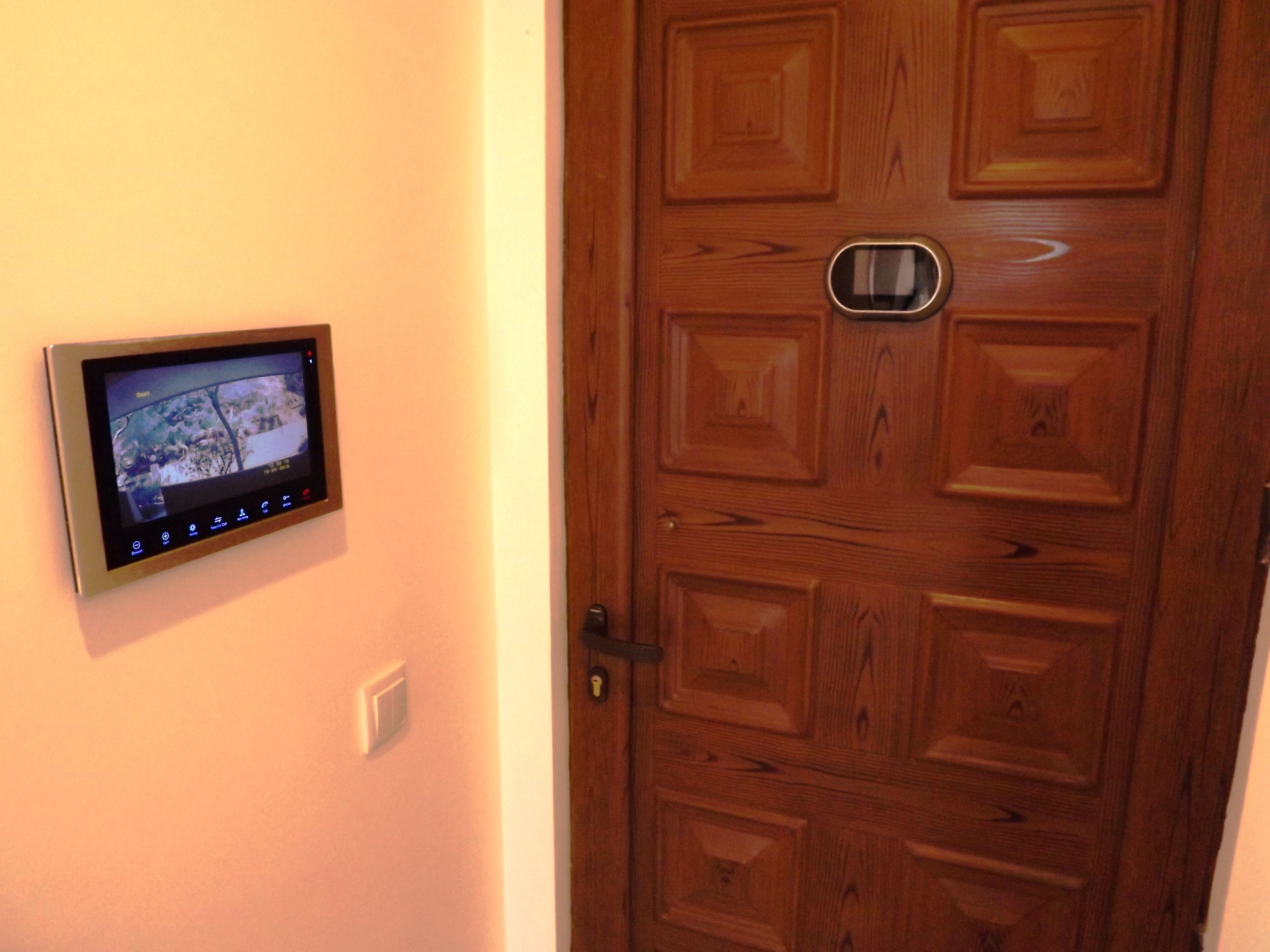 Une porte avec une caméra de surveillance fixée au mur à côté.