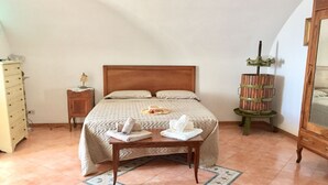 A bedroom with a bed, bedside table, and a wooden cabinet.