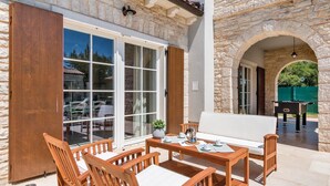 An outdoor patio with wooden furniture, stone walls, and a view of the surrounding area. - Villa San Kirin ***** Lavanda, five stars with Whirlpool, Sauna, billiard ... (Vodnjan)