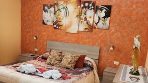 Ein Schlafzimmer mit einem Bett, einem Nachttisch, einer Kommode, einer Klimaanlage und einem Wandbild.