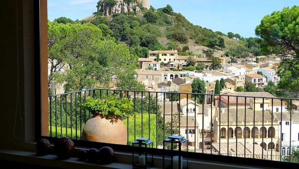 A balcony with a view of a hillside town, including a castle-like structure. - Modern Villa (Center Of Begur) Overlooking Both Village And Sea (Begur)