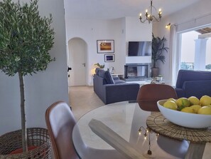 Relax in this stylish living room with a round table, blue sofa, and potted plant.