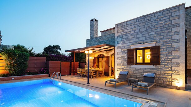 A swimming pool with lounge chairs and a covered patio area. - Family villa Elia with heated pool, 2 minutes walking to local amenities (Rethymno)