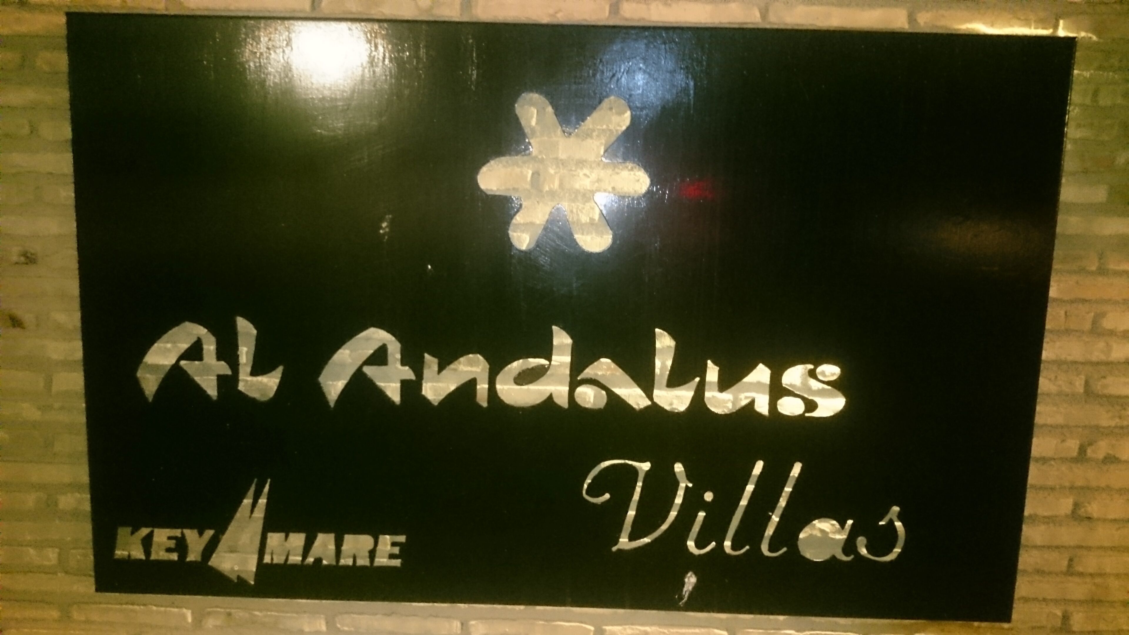 A sign with the text "Al Andalus Villas" and "KEYMARE" on a black background.