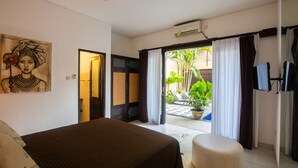 Une chambre d’hôtel avec un lit, un tableau, une télévision et une vue sur l’extérieur.
