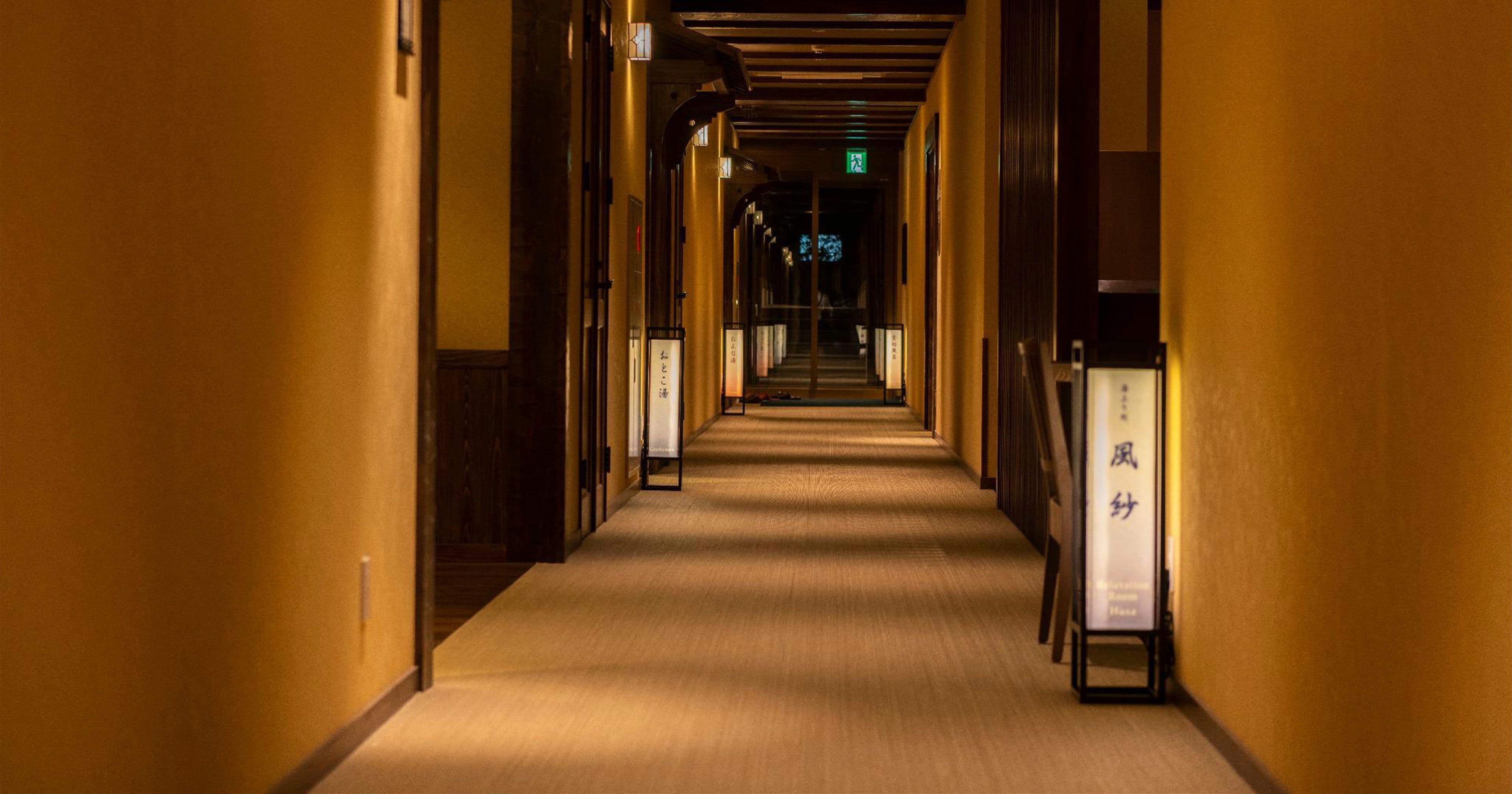 Un pasillo de hotel con piso alfombrado y paredes de madera.