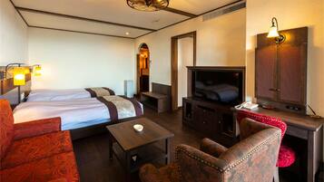 Quarto com quatro camas, televisão, área de estar e espelho.