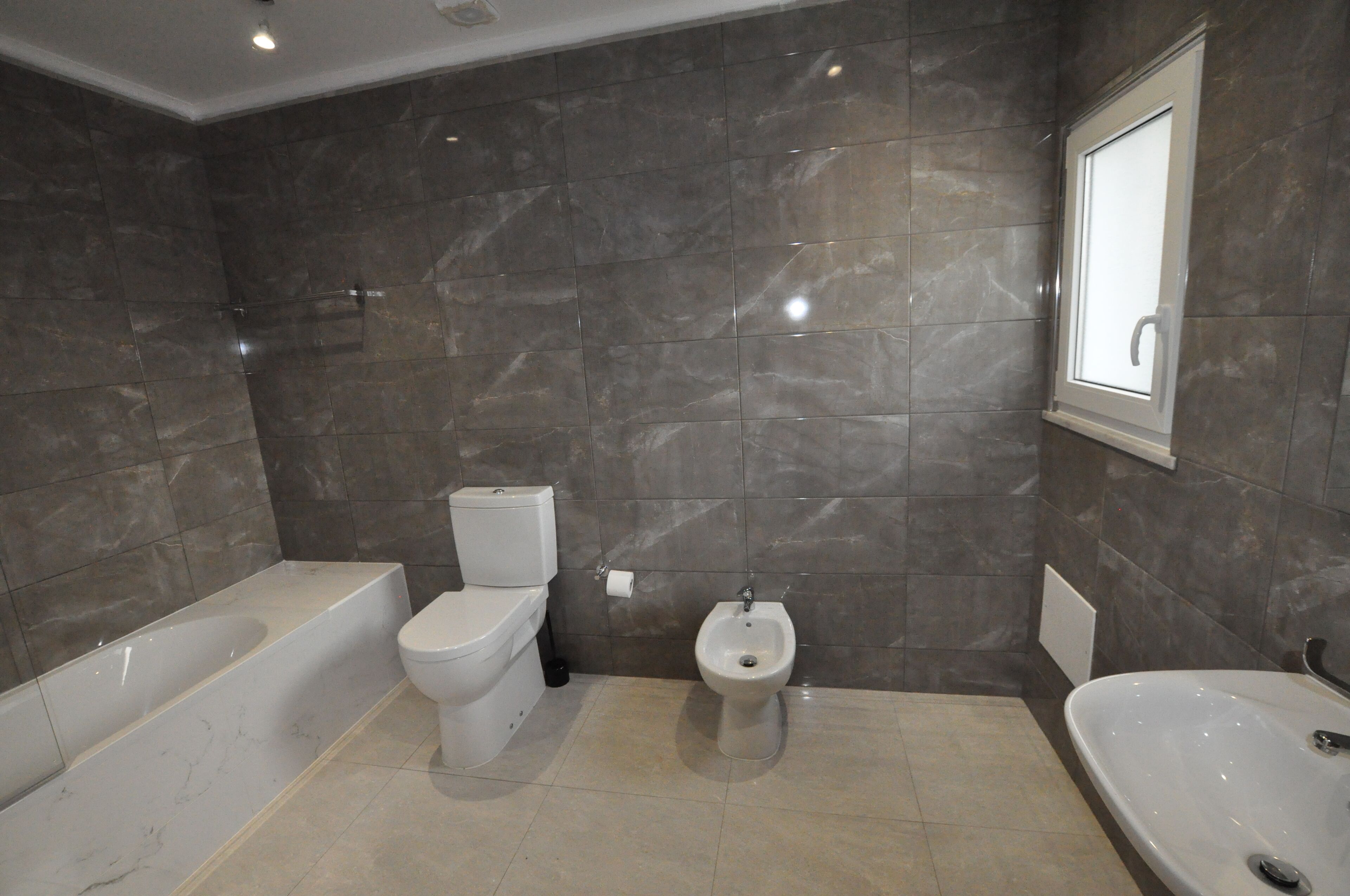 Ein Badezimmer mit Badewanne, Toilette, Bidet und Waschbecken.