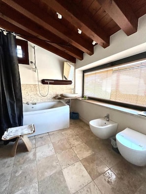 Tina con regadera, secadora de cabello, bidet, toallas 