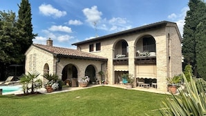 A two-story stone house with a swimming pool, arched windows, and a well-maintained lawn. - Damabianca junior (Porto Gruaro)