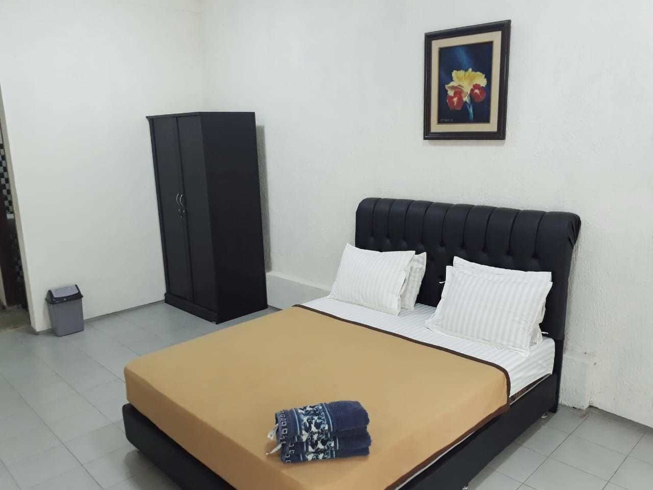 A bedroom with a bed, a wardrobe, and a framed picture on the wall.