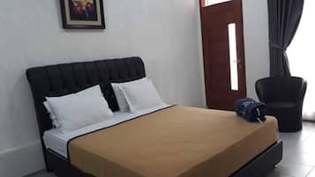 Un dormitorio con una cama, una silla, una puerta y un cuadro en la pared.