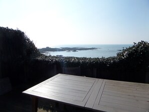 Ein Holztisch mit Blick auf das Meer und das entfernte Land.