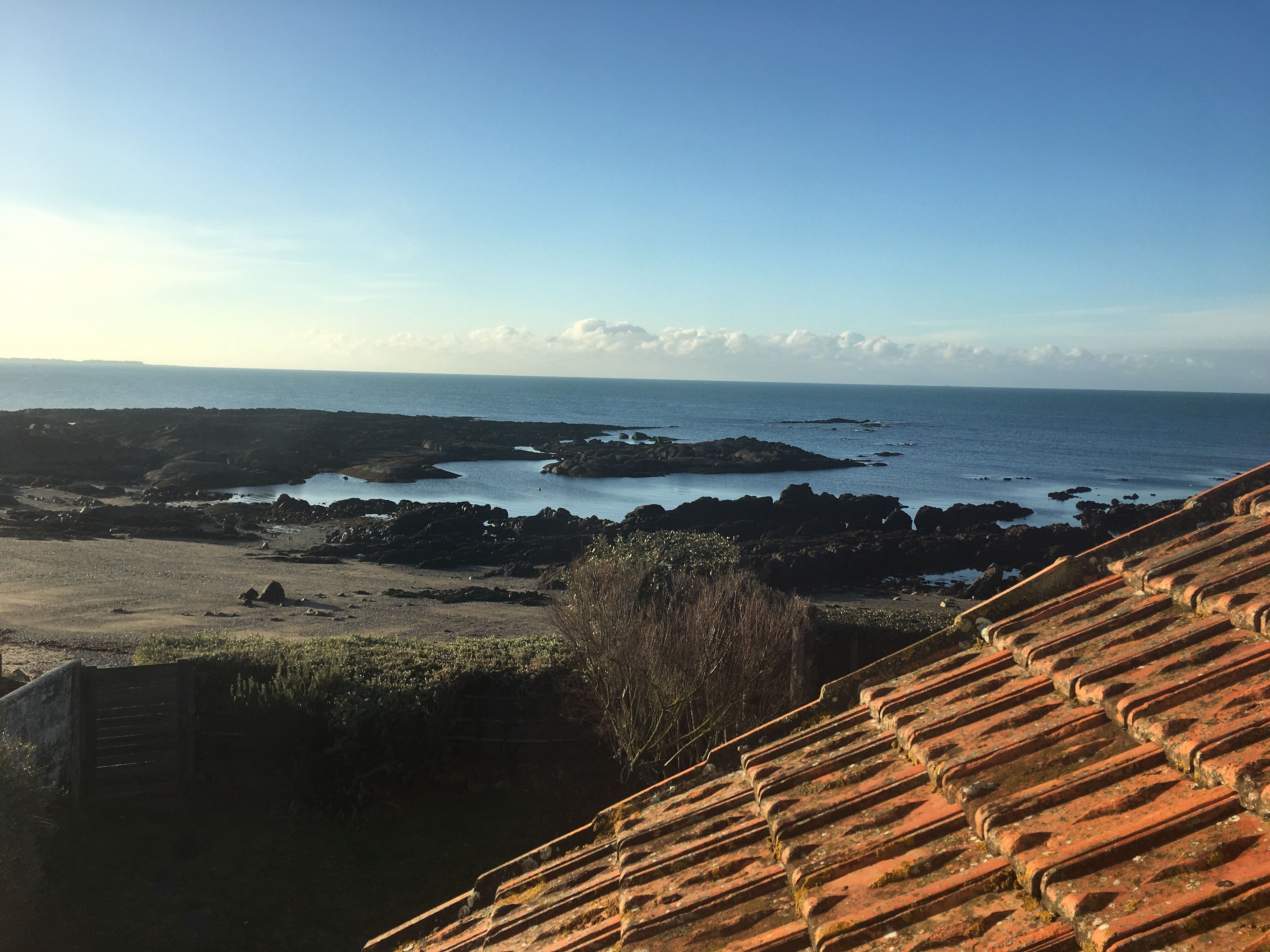Eine Küstenlandschaft mit felsigem Gelände und freiem Blick auf das Meer.