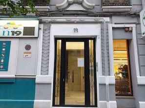 A building with a number 19 sign above a black-framed door. - Spacious and central apartment with terrace, very comfortable, for families. (Valencia)
