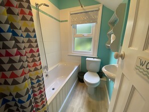 A bathroom with a bathtub, toilet, and sink.