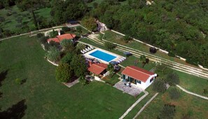 An aerial view of a property with a swimming pool, multiple buildings, and surrounding greenery. - Holiday Home Campo with pool (Rovinj)