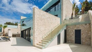A modern building with a stone facade, a glass staircase, and a clear sky. - Wonderful private villa for 8 guests with private pool, hot tub, WIFI, A/C, TV and terrace (Prigradica)