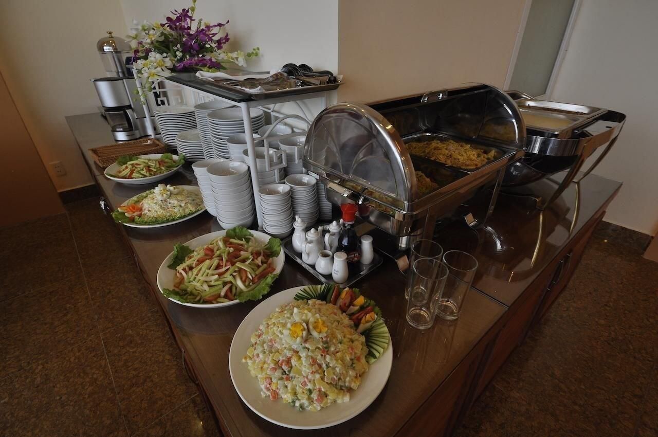 A buffet setup with various dishes, including salads and a large bowl of potato salad, and a coffee machine in the background.