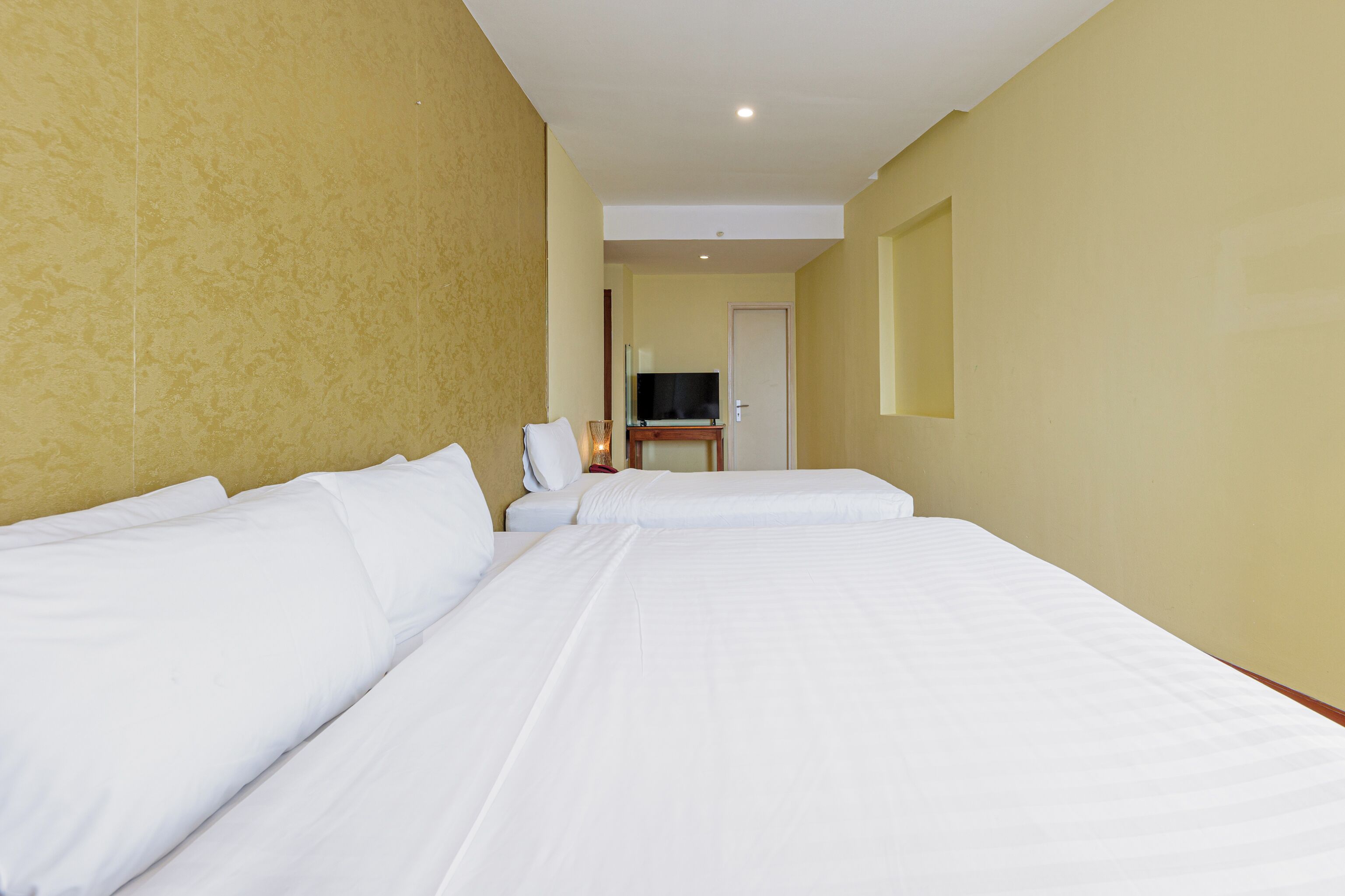 A hotel room with two beds, a television, and a small table.