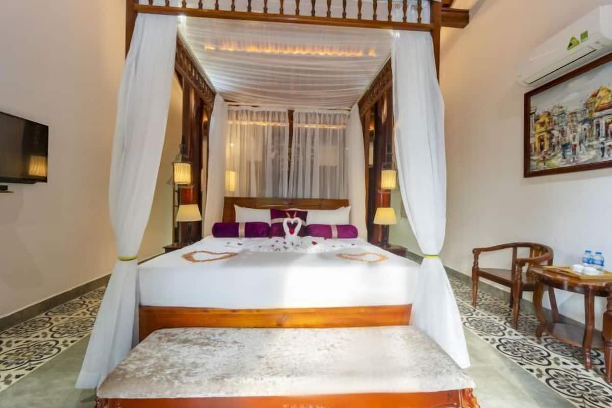Un lit à baldaquin, une table de chevet avec une lampe et une chaise.