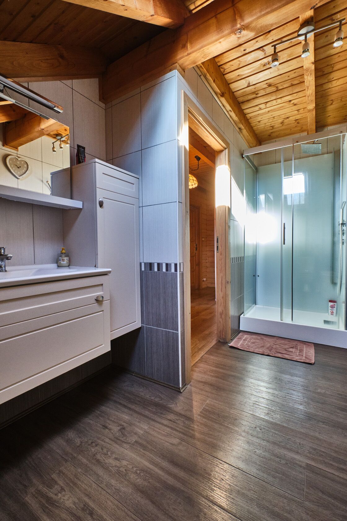 Une cuisine moderne dotée d’un réfrigérateur encastré, de meubles en bois et d’un plafond en bois.