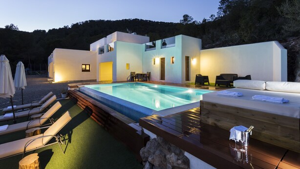 A modern outdoor pool area with lounge chairs, a hot tub, and a wooden deck.