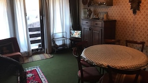 A cozy room with a round table, a television, and a patterned wall. - A comfortable vacation in Aprica - Cable car and swimming pool 100 meters away (Aprica)