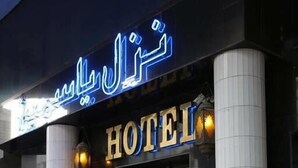 A hotel entrance with a prominent sign, large columns, and a red rope barrier. - Hotel Yasmine (Sfax)