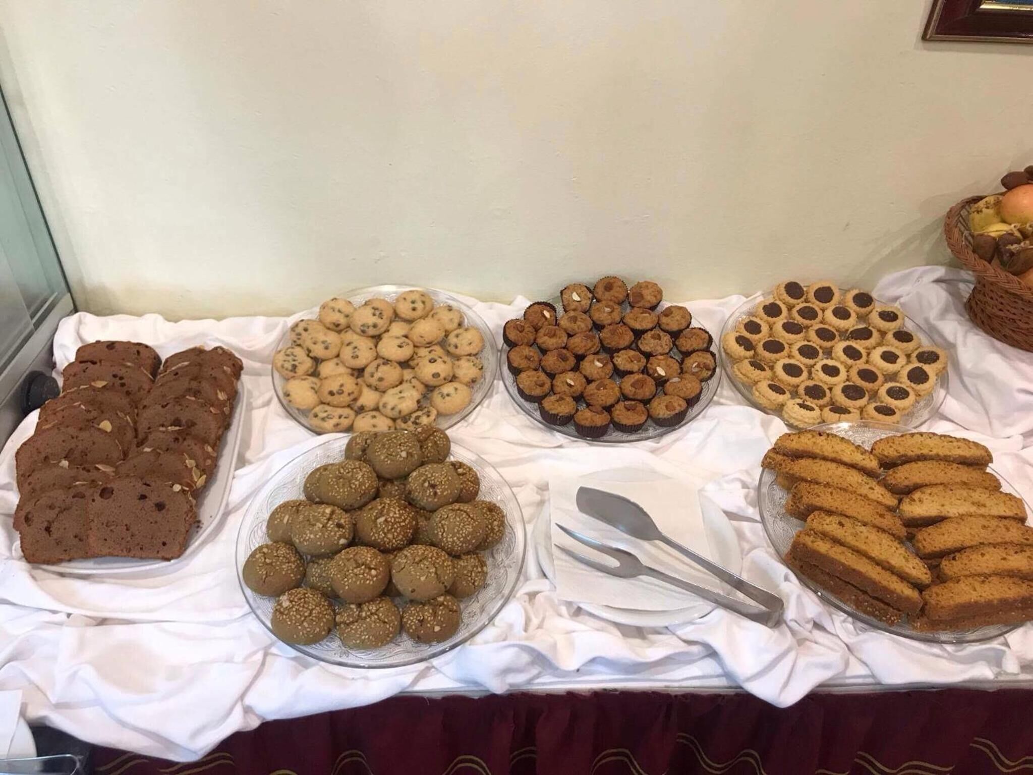 A buffet table with various baked goods including cookies, brownies, and other desserts.