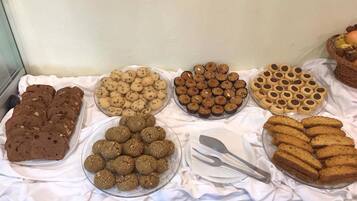 A buffet table with various baked goods including cookies, brownies, and other desserts.