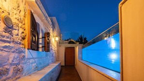 A narrow, stone-walled corridor with a wooden door and a window overlooking a blue-lit area. - Superb villa Rogdia with heated pool, 2 minutes walking from local amenities (Rethymno)