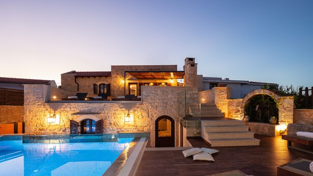 A luxurious poolside area with a stone building, a swimming pool, and outdoor seating. - Superb villa Rogdia with heated pool, 2 minutes walking from local amenities (Rethymno)