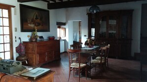Une salle à manger traditionnelle avec une table en bois, des chaises et un grand tableau accroché au mur.